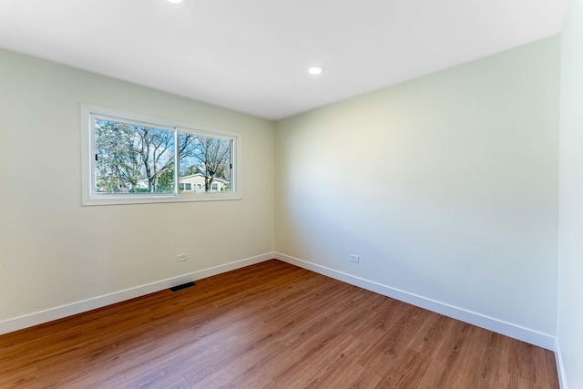 unfurnished room with recessed lighting, baseboards, visible vents, and light wood-style flooring