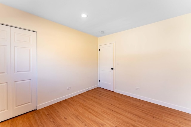 unfurnished bedroom with light wood-style floors, baseboards, a closet, and recessed lighting