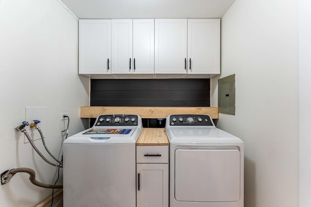 washroom featuring washing machine and clothes dryer, cabinet space, and electric panel