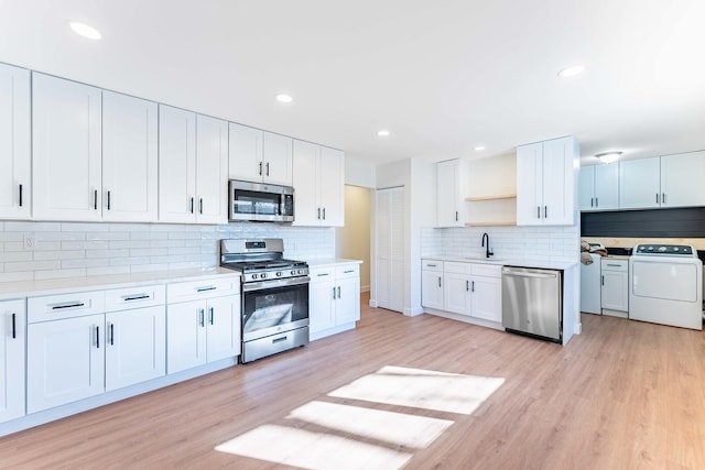 kitchen with open shelves, decorative backsplash, washer / clothes dryer, light countertops, and appliances with stainless steel finishes