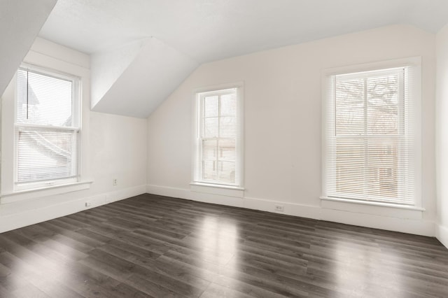 bonus room featuring baseboards, dark wood-style flooring, and vaulted ceiling