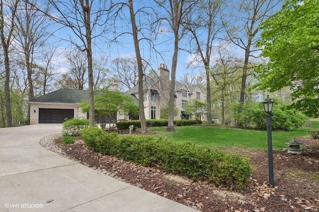 view of front facade featuring an attached garage, concrete driveway, and a front lawn