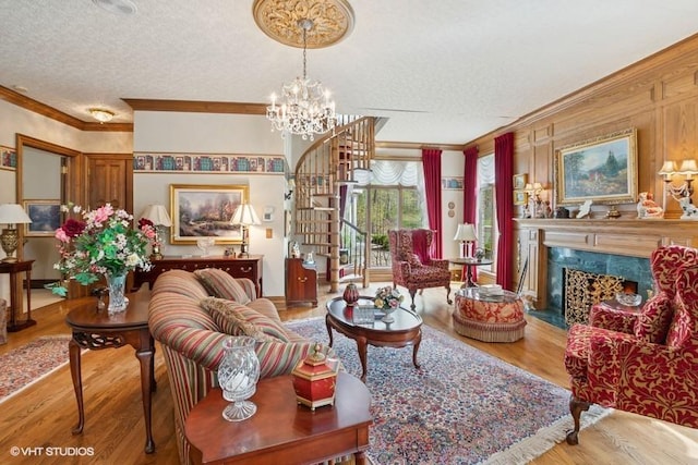 living room featuring crown molding, stairs, wood finished floors, a high end fireplace, and a textured ceiling