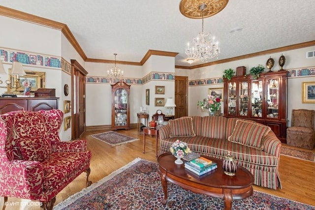 living area with a textured ceiling, visible vents, crown molding, wood finished floors, and a notable chandelier