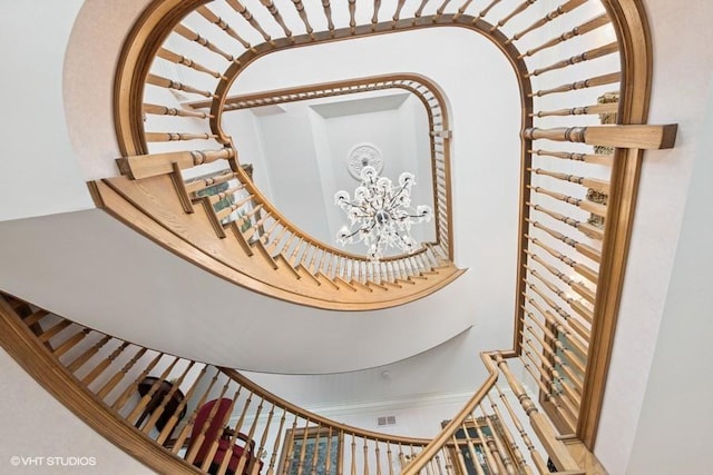 staircase with a chandelier