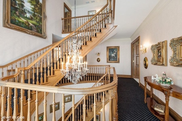 staircase with carpet floors, a chandelier, ornamental molding, and a towering ceiling