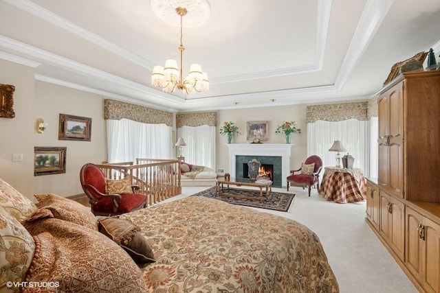 carpeted bedroom featuring an inviting chandelier, ornamental molding, a raised ceiling, and a fireplace