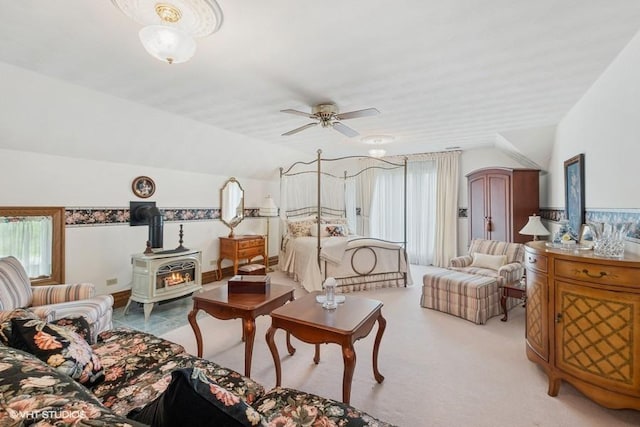 living room featuring a wood stove, a ceiling fan, and lofted ceiling