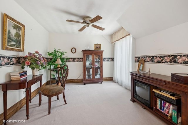 home office featuring baseboards, a ceiling fan, and light carpet
