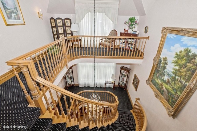 stairs featuring arched walkways and carpet flooring