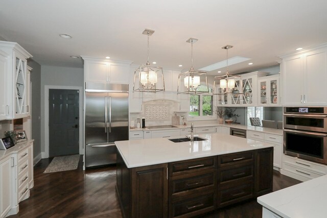 67 Katrina Ln, Sleepy Hollow, IL 60118 - kitchen with stainless steel appliances, a sink, light countertops, dark wood finished floors, and white cabinets