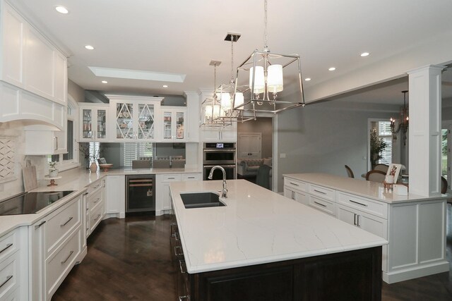 67 Katrina Ln, Sleepy Hollow, IL 60118 - kitchen featuring black electric stovetop, a sink, wine cooler, stainless steel double oven, and a center island with sink