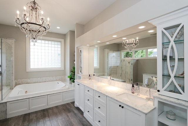 67 Katrina Ln, Sleepy Hollow, IL 60118 - bathroom with a chandelier, a stall shower, a jetted tub, double vanity, and wood finished floors