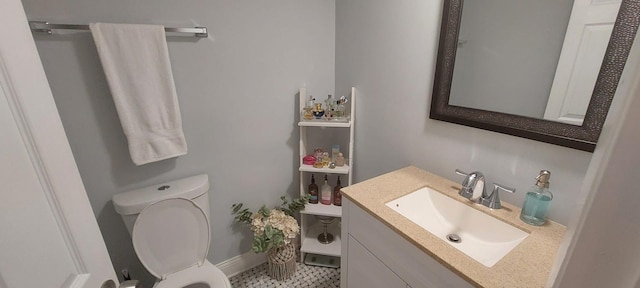 bathroom featuring vanity, baseboards, and toilet