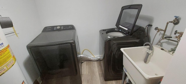 laundry area featuring washer / dryer, water heater, and wood finished floors