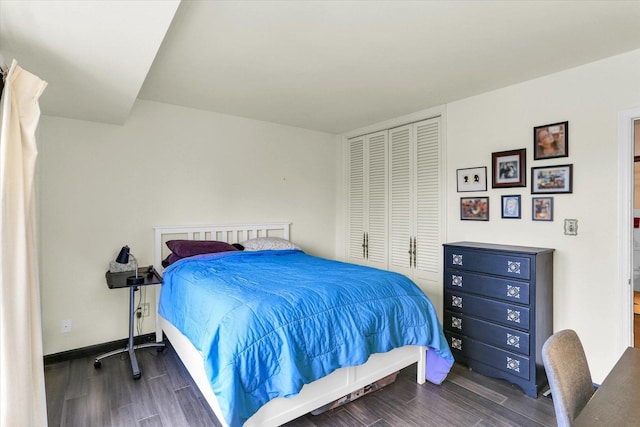 bedroom featuring wood finished floors, a closet, and baseboards