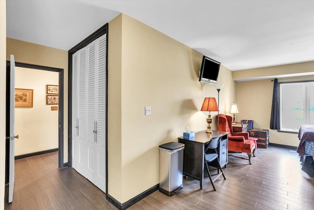 corridor featuring wood finished floors and baseboards
