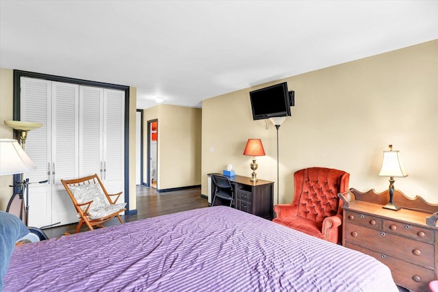 bedroom featuring dark wood finished floors, a closet, and baseboards