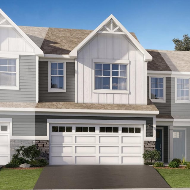 townhome / multi-family property with aphalt driveway, board and batten siding, and stone siding