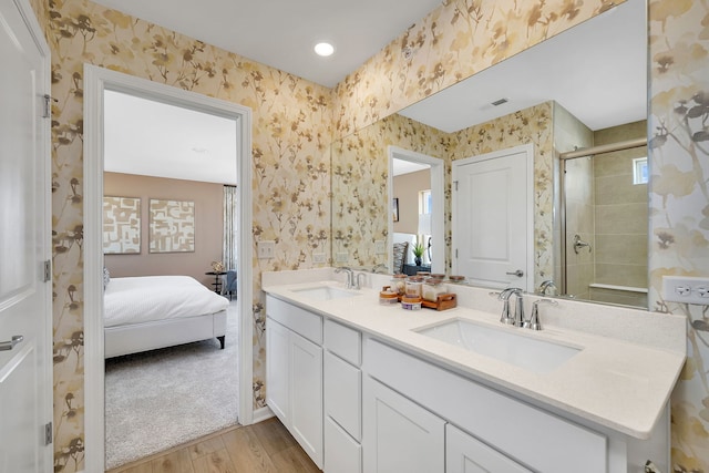 ensuite bathroom with a sink and wallpapered walls