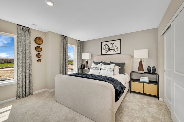 bedroom featuring baseboards, carpet flooring, visible vents, and a closet
