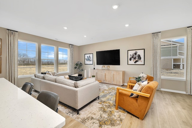 living room featuring light wood-style floors, baseboards, and recessed lighting