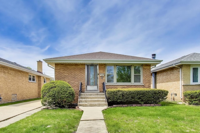 bungalow-style house featuring a front lawn, brick siding, entry steps, and a shingled roof