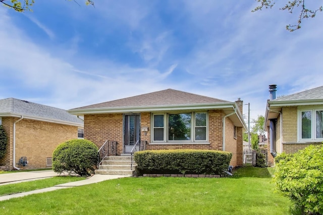 bungalow with a front lawn and brick siding