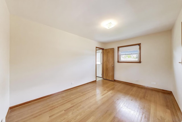 empty room featuring light wood-style flooring and baseboards
