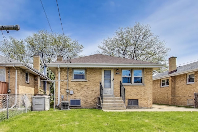 back of house with entry steps, brick siding, central AC, and a chimney