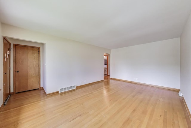 spare room featuring light wood-style flooring and baseboards