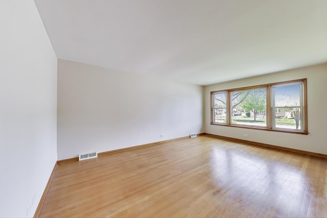 unfurnished room with light wood-style flooring and baseboards