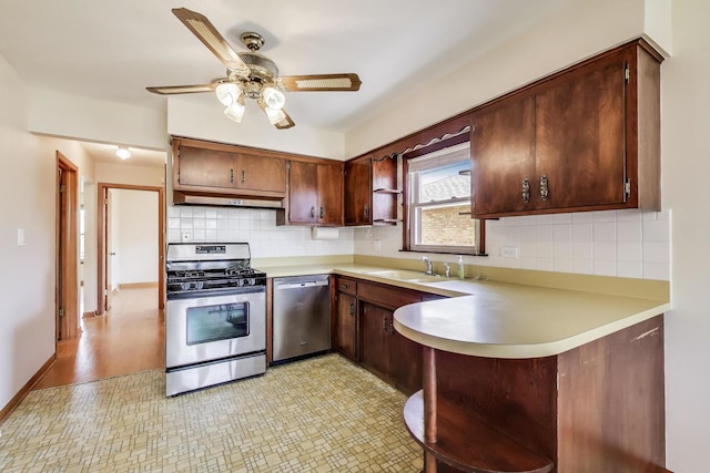 kitchen featuring stainless steel appliances, a peninsula, light countertops, a sink, and ceiling fan