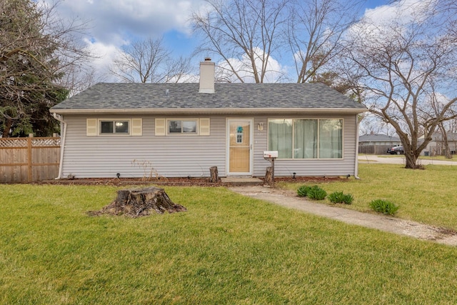 exterior space with a lawn, fence, a chimney, and a shingled roof