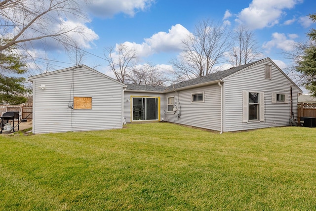 rear view of house featuring a yard, central AC, and fence