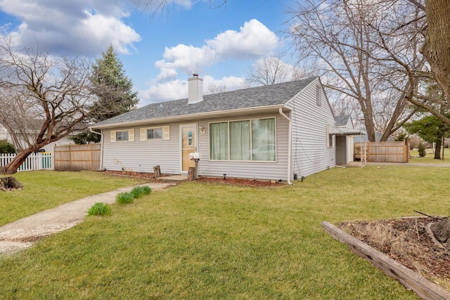 view of front of house with fence, a chimney, a shingled roof, and a front lawn