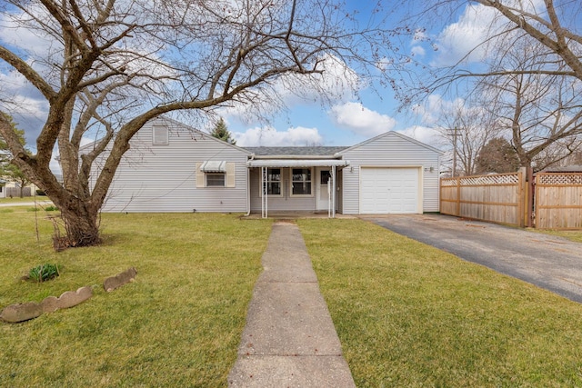 view of front of house with an attached garage, fence, a front lawn, and aphalt driveway