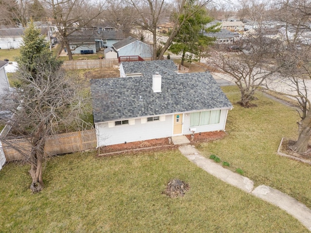 view of front of home with fence, a shingled roof, a chimney, and a front lawn
