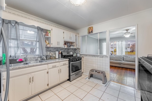 kitchen with crown molding, open shelves, stainless steel gas range, light countertops, and a sink