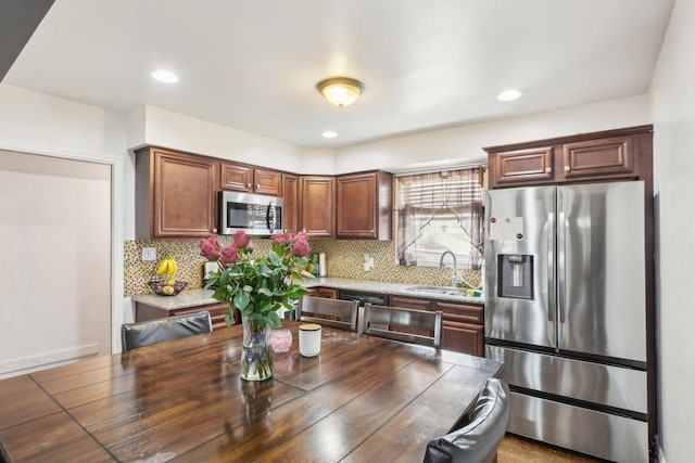 kitchen featuring stainless steel appliances, a sink, and tasteful backsplash