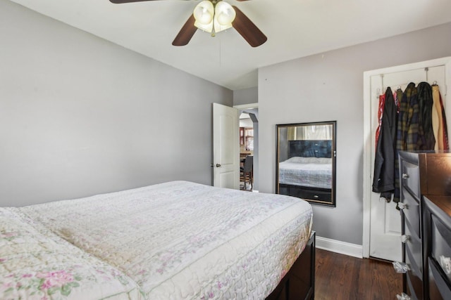 bedroom with baseboards, a ceiling fan, and dark wood-style floors