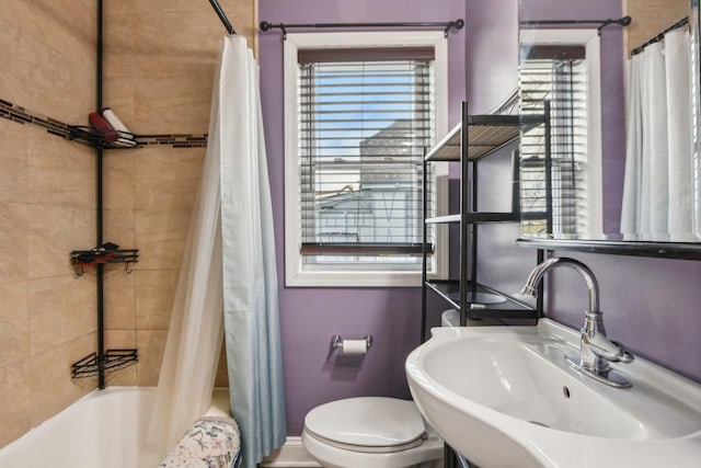 bathroom with a sink, toilet, and shower / tub combo with curtain