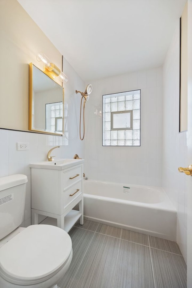 bathroom with shower / tub combination, plenty of natural light, toilet, and tile walls