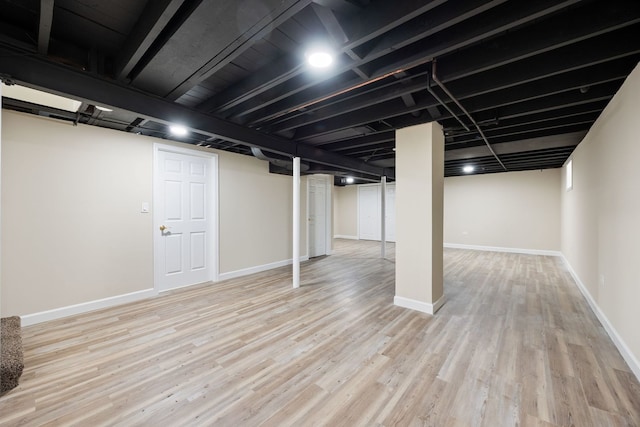 finished below grade area featuring baseboards and wood finished floors