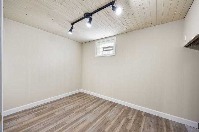 below grade area with baseboards, wood ceiling, and light wood-style flooring
