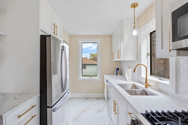 kitchen featuring a sink, light stone counters, marble finish floor, stainless steel appliances, and white cabinetry