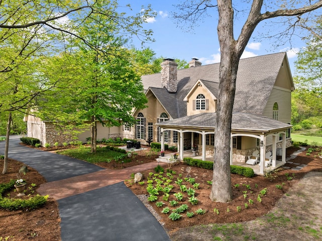2S546 Heaton Dr, Batavia, IL 60510 - view of front facade featuring stone siding, a chimney, and a shingled roof
