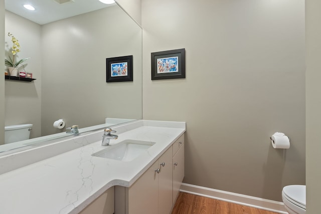 2S546 Heaton Dr, Batavia, IL 60510 - half bathroom with toilet, wood finished floors, baseboards, and vanity
