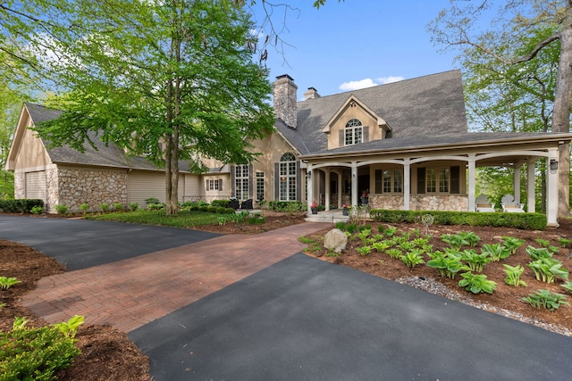 2S546 Heaton Dr, Batavia, IL 60510 - view of front of home with stone siding, covered porch, a chimney, and a shingled roof