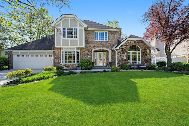 view of front of home with a front yard, an attached garage, and driveway
